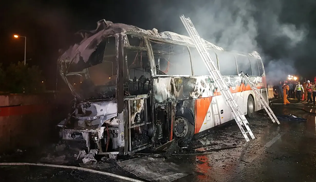 Kondisi bangkai bus pariwisata yang hangus terbakar di Gyeongbu Expressway, tenggara Kota Ulsan, Korsel, Kamis (13/10). Sebagian besar penumpang merupakan pensiunan sebuah perusahaan yang kembali dari bandara setelah perjalanan dari Tiongkok. (Yonhap/AFP)