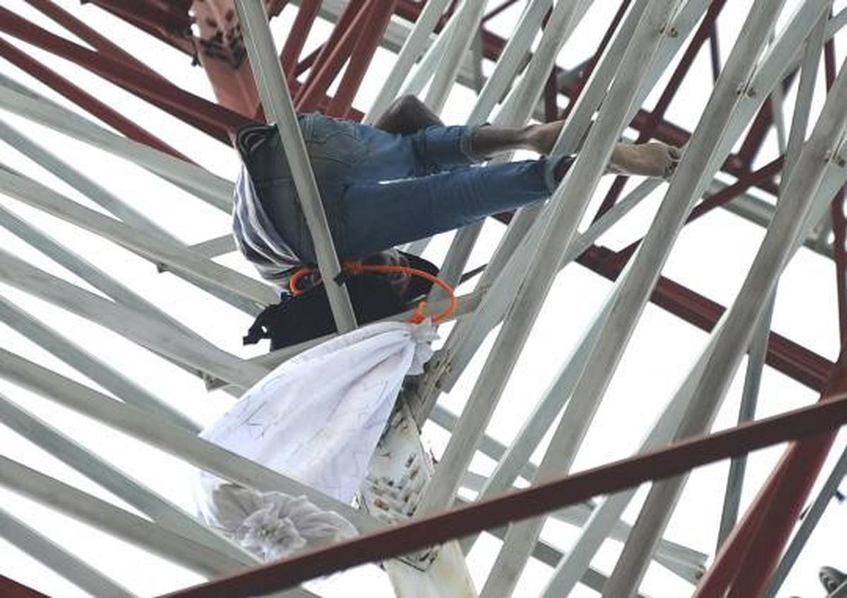 Pria berpakaian pocong di atas tower SUTET