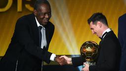 Lionel Messi menerima trofi FIFA Balon d'Or 2015 dari Presiden interim FIFA, Issa Hayatou, dalam acara di Kongresshaus, Zurich, Swiss, Selasa (12/1/2016) dini hari WIB. (AFP/Olivier Morin)