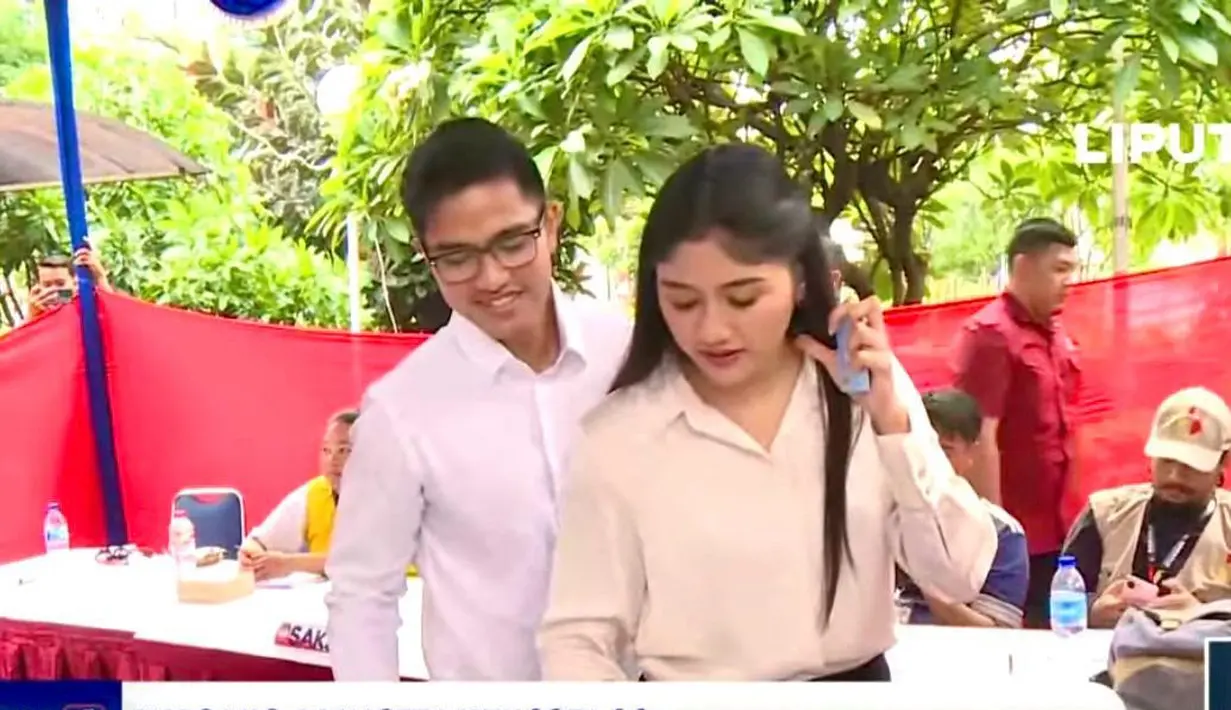 Kaesang menggunakan kemeja lengan panjang berwarna putih yang dipadukan dengan celana panjang berwarna krem. Sementara, Erina mengenakan atasan berwarna putih gading dan celana panjang berwarna hitam. [YouTube/SCTV/Indosiar]