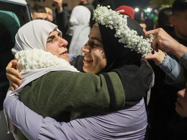 Tahanan Palestina, Baraah Fuqaha (kanan) disambut oleh kerabatnya pada saat kedatangan pada dini hari tanggal 20 Januari 2025 di kota Tepi Barat yang diduduki, Beitunia, di pinggiran kota Ramallah. (Zain JAAFAR/AFP)