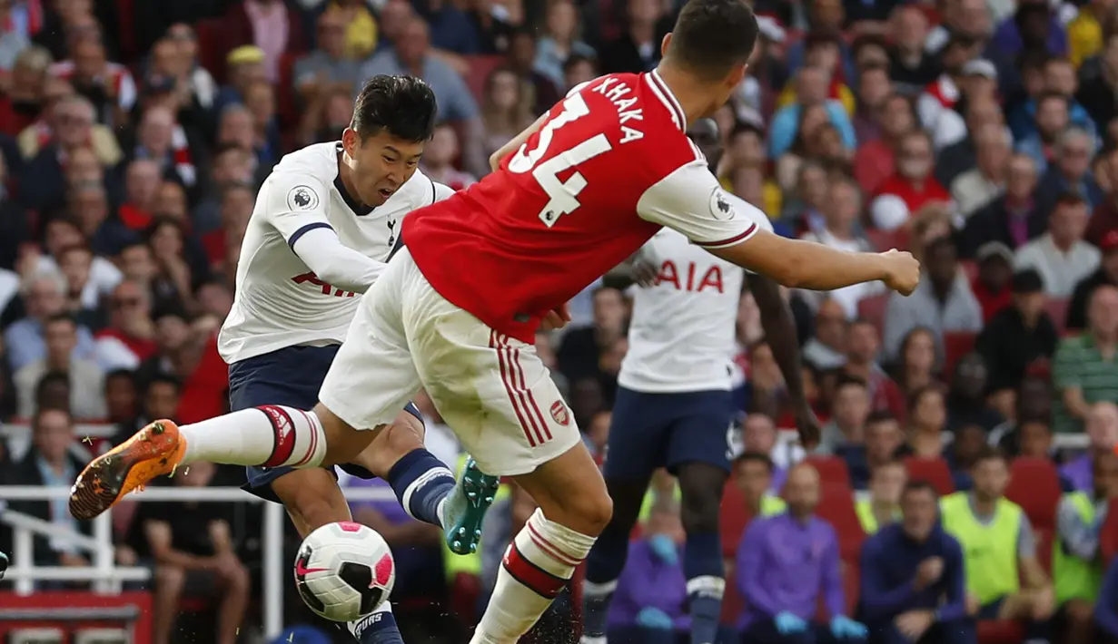 Penyerang Tottenham Hotspur,  Son Heung-min menendang bola ke arah gawang Arsenal pada pertandingan Liga Inggris di stadion Emirates di London (1/9/2019). Arsenal bermain imbang 2-2 atas Tottenham. (AP Photo/Alastair Grant)
