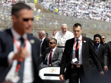 Paus Fransiskus melambaikan tangan saat tiba untuk merayakan Misa bagi komunitas Katolik Mesir di stadion militer Kota Kairo, Mesir, (29/4). Pemimpin umat Katolik dunia ini berkunjung ke Mesir untuk membawa pesan damai. (AP Photo/Gregorio Borgia)