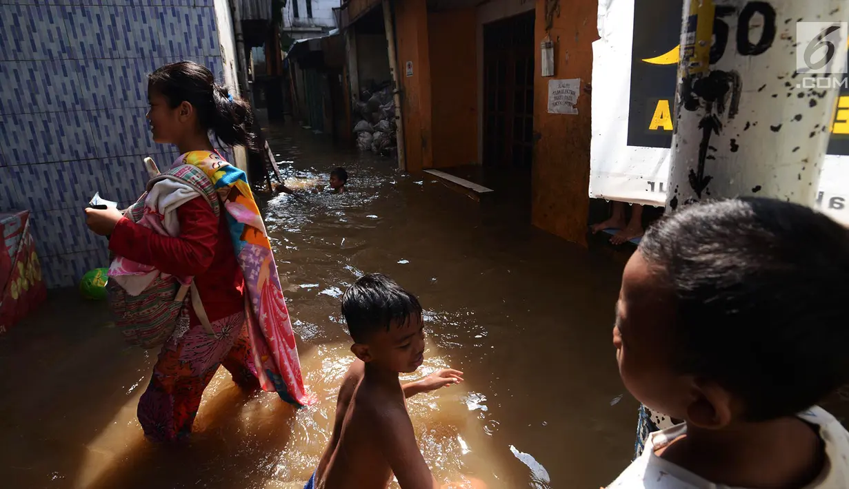 Aktivitas warga saat banjir merendam permukiman di Kebon Pala, Jatinegara, Jakarta, Selasa (26/2/2019). Banjir setinggi 1,5 meter tersebut terjadi karena air Sungai Ciliwung meluap akibat air kiriman dari Bogor, Jawa Barat. (Merdeka.com/Imam Buhori)