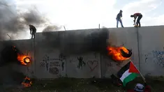 Pengunjuk rasa Palestina memanjat tembok pemisah dengan Israel saat aksi di desa Tepi Barat Bilin dekat Ramallah, Jumat (17/2). Aksi tersebut untuk memperingati 12 tahun protes mereka atas tembok pemisah tersebut. (AP Photo / Majdi Mohammed)