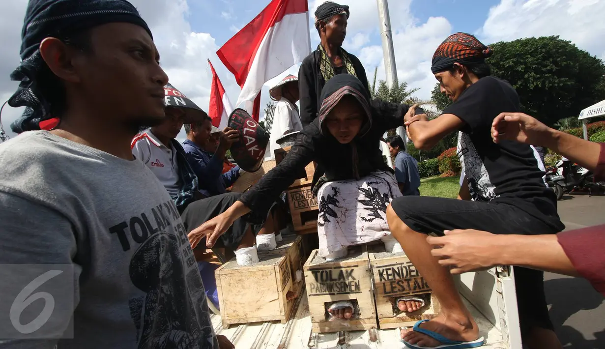 Aksi menyemen kaki di depan Istana Negara, Jakarta, Rabu (15/3). Di hari ketiga jumlah pengunjuk rasa yang memasung kaki bertambah hingga total berjumlah 20 orang. (Liputan6.com/Immanuel Antonius)