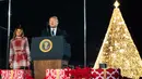 Presiden AS, Donald Trump didampingi ibu negara Melania Trump memberikan sambutan saat upacara penerangan Pohon Natal Nasional di taman sebelah selatan Gedung Putih, Kamis (5/12/2019). Pohon Natal Nasional tahun ini adalah cemara biru segar dari Colorado. (AP/Manuel Balce Ceneta)