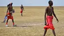 Suku Maasai membawa peralatannya untuk mengikuti pertandingan amal kriket di kaki Gunung Kenya (18/6). Mereka juga berusaha menggalang dana untuk penelitian yang berguna untuk menyelamatkan spesies badak putih. (AFP Phoo/Tony Karumba)