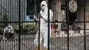 Petugas kemanan mengenakan baju hazmat saat menjaga aktivitas pasien di sebuah hotel kawasan Salemba, Jakarta, Senin (22/2/2021). Para pasien Covid-19 memilih hotel dengan alasan lebih nyaman dan privasi dibandingkan rumah sakit meskipun mengeluarkan biaya lebih.  (merdeka.com/Iqbal S. Nugroho)