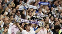 Para suporter Real Madrid merayakan keberhasilan tim kesayangannya menaklukan Manchester City pada semifinal Liga Champions. Partai puncak menghadapi Atletico akan dihelat di San Siro, 28 Mei 2016. (AFP/Gerard Julien)