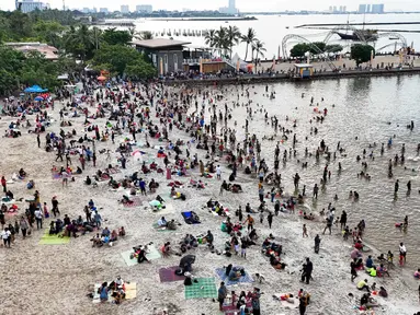 Foto udara memperlihatkan suasana Pantai Ancol Taman Impian, Jakarta, Selasa (1/4/2025) saat libur hari kedua perayaan Idul Fitri 1446 Hijriah. (Liputan6.com/Herman Zakharia)