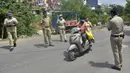 Polisi menghentikan pengendara untuk memeriksa dokumen identifikasi mereka selama penguncian yang diberlakukan sebagai tindakan pencegahan terhadap penyebaran COVID-19 di Bangalore, India, Senin (24/5/2021). Kematian akibat COVID-19 di India telah menembus 300 ribu orang. (Manjunath Kiran/AFP)
