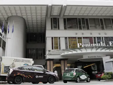 Sejumlah mobil melintas di depan Hotel Peninsula Excelsior, Singapura, Rabu (7/11). Hotel bintang empat ini menjadi tempat menginap Timnas Indonesia jelang Piala AFF 2018. (Bola.com/M. Iqbal Ichsan)