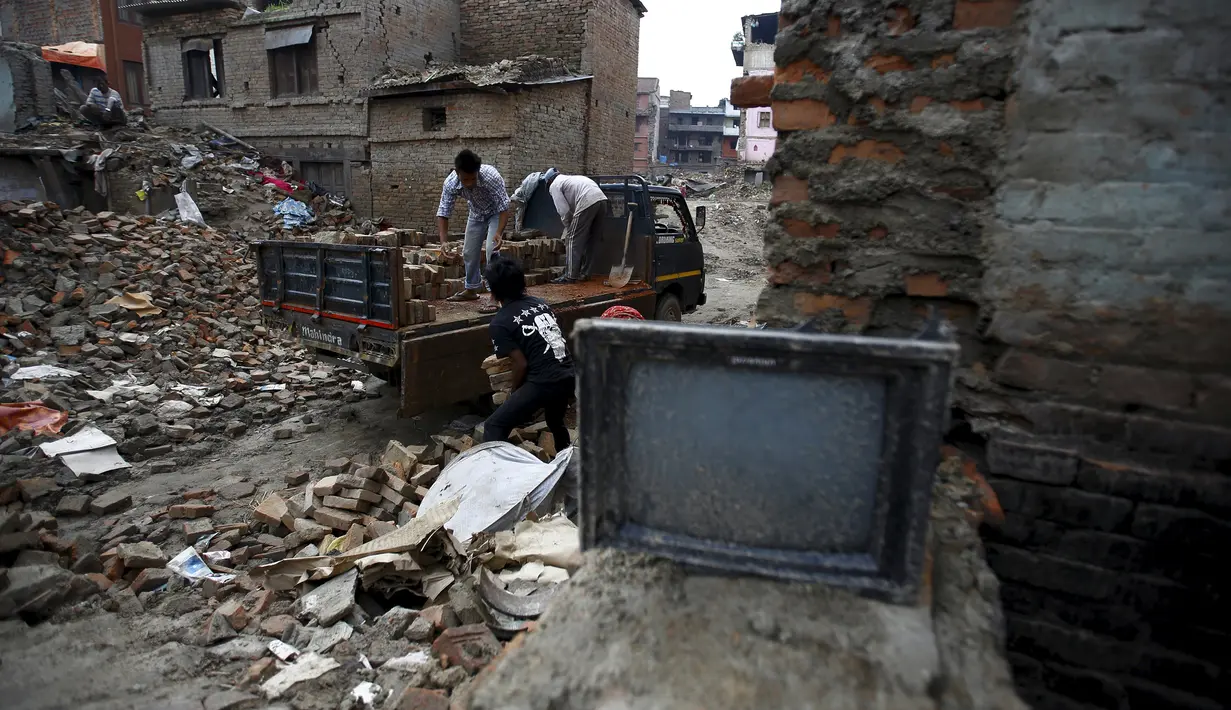 Sejumlah Warga mengumpulkan puing-puing bangunan yang rusak akibat gempa di Bhaktapur, Nepal (14/7/2015). PBB melaporkan dua bulan setelah gempa di Nepal, warga masih sulit mendapatkan makanan dan perawatan kesehatan. (REUTERS/Navesh Chitrakar)