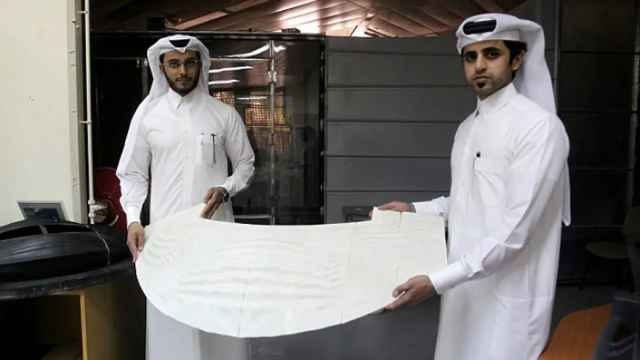 Insinyur mesin Abdullah Mojeb Aldar (kiri) dan Fahad al-Musalam tampak membawa model stadion yang dibuat menggunakan mesin cetak 3D 