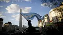Seorang wanita memegang bendera Argentina selama berunjuk rasa menentang berbagai masalah termasuk kebijakan ekonomi pemerintah dan negara untuk melawan penyebaran COVID-19 di Buenos Aires, Argentina, Senin (12/10/2020). (AP Photo/Natacha Pisarenko)