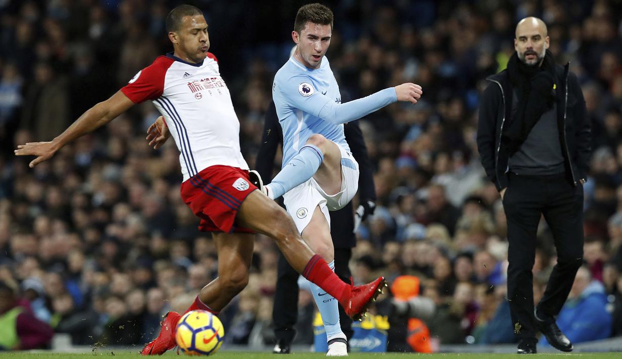 Aymeric Laporte (kanan) melepaskan tembakan melewati adangan pemain West Bromwich, Salomon Rondon pada lanjutan Premier League di The Etihad Stadium, Manchester, (31/1/2018). Manchester City menang 3-0. (Martin Rickett/PA via AP)