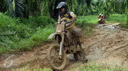 Peserta Komando Trail Adventure (Kotra) 2 mencoba menaklukkan lintasan berlumpur di kawasan Kebun Kelapa Sawit, Bogor, Jawa Barat, Sabtu (8/4). Acara ini bagian perayaan HUT Kopassus ke-65 dan diikuti ribuan kroser. (Liputan6.com/Helmi Fithriansyah) 