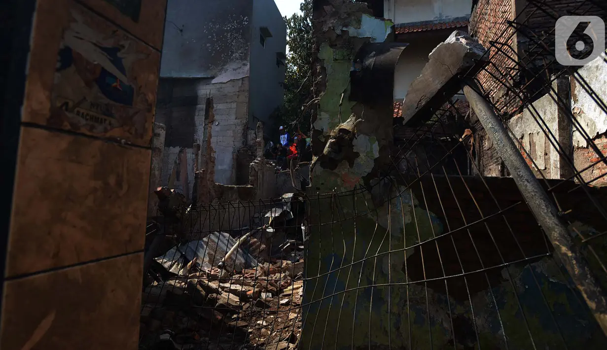 Warga membesihkan sisa barang dalam rumah yang terbakar di RW 02, Kelurahan Bidari Cina, Jakarta, Selasa (22/10/2019). Tidak ada korban jiwa akibat kebakaran tersebut yang menghanguskan 56 rumah tersebut. (merdeka.com/Imam Buhori)