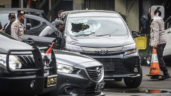 Petugas kepolisian mengecek salah satu mobil yang rusak pascapenyerangan di Polsek Ciracas, Jakarta, Sabtu (29/8/2020). Polsek Ciracas  diserang oleh sejumlah orang tak dikenal pada Sabtu (29/8) dini hari. (Liputan6.com/Faizal Fanani)