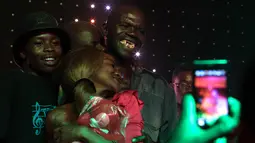 Maison Sere merayakan kemenangannya usai dinobatkan sebagai pria terjelek pada kontes 'Ugliest Man' di Zimbabwe, 20 November 2015. Sere sendiri adalah pria pengangguran yang menang dalam kontes tersebut. (AFP PHOTO/Jekesai NJIKIZANA)