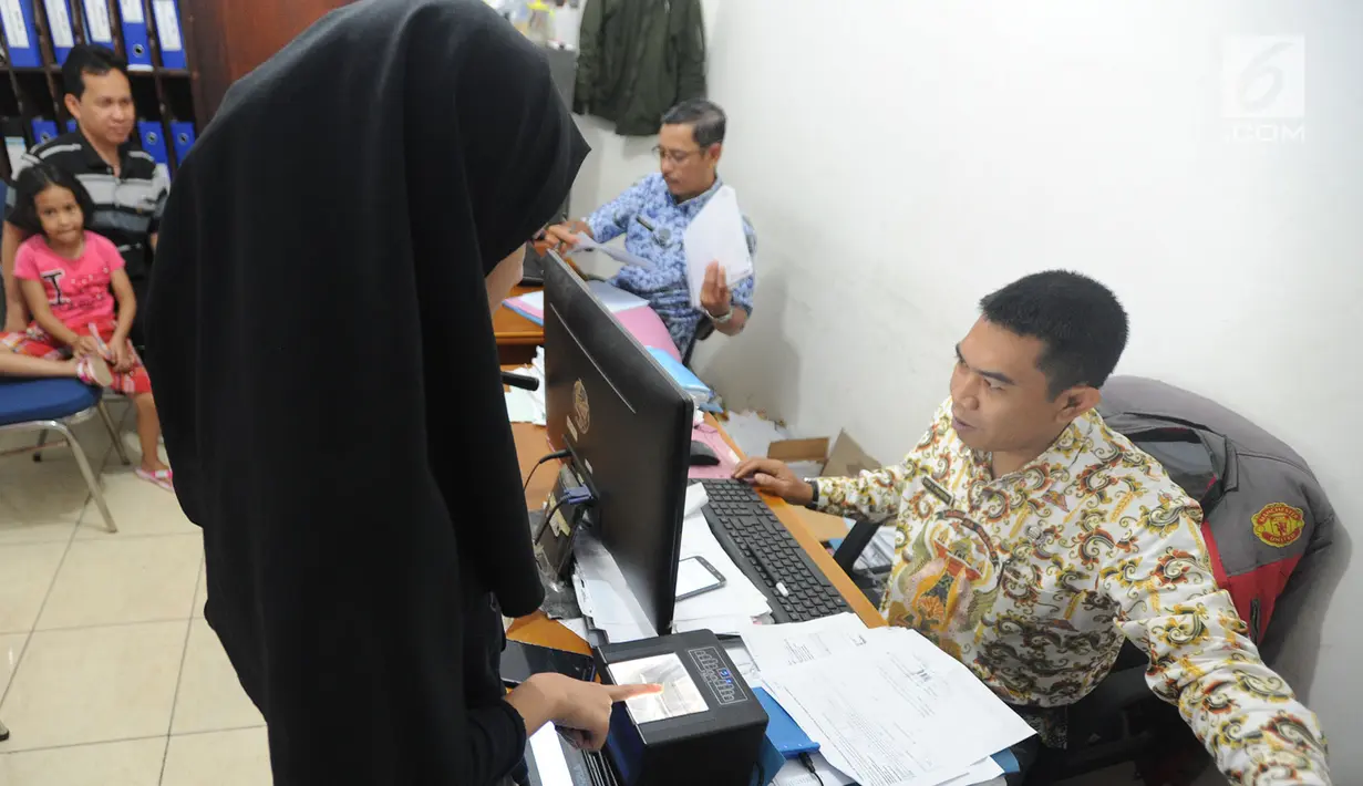 Petugas melakukan perekaman sidik jari warga saat pembuatan E-KTP di Kantor kelurahan Cinere, Depok, Kamis (27/12). Hari ini dilaksanakan pelayanan jemput bola perekaman E-KTP serentak khusus pemula secara nasional. (Merdeka.com/Arie Basuki)