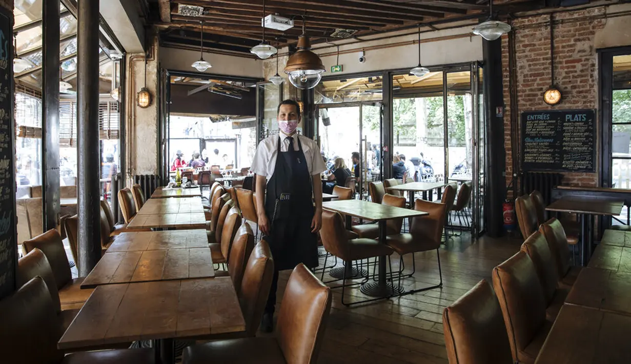 Pelayan Restoran Le Jaures Sami El Ouardi (32) berfoto dalam restoran sehari sebelum pembukaan kembali restoran dalam ruangan secara nasional di Paris, Prancis, Selasa (8/6/2021). Prancis akan membuka restoran dalam ruangan pada 9 Juni 2021. (AP Photo/Lewis Joly)