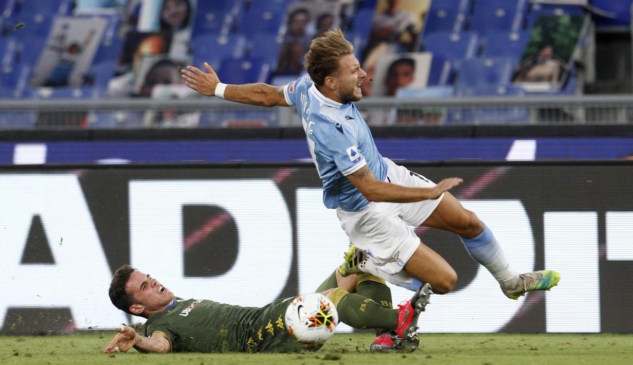 Penyerang Lazio, Ciro Immobile, berebut bola dengan bek Brescia, Andrea Papetti, pada laga lanjutan Serie A pekan ke-37 di Stadion Olimpico, Kamis (30/7/2020) dini hari WIB. Lazio menang 2-0 atas Brescia. (AP Photo/Riccardo De Luca)