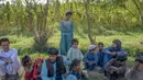 Seorang pria beristirahat bersama anak-anak di samping ladang ganja pinggiran Kandahar, Afghanistan, 28 Oktober 2021. Taliban bersumpah akan menindak perdagangan obat-obatan terlarang yang sebagian besar memicu pemberontakan mereka yang berhasil. (BULENT KILIC/AFP)