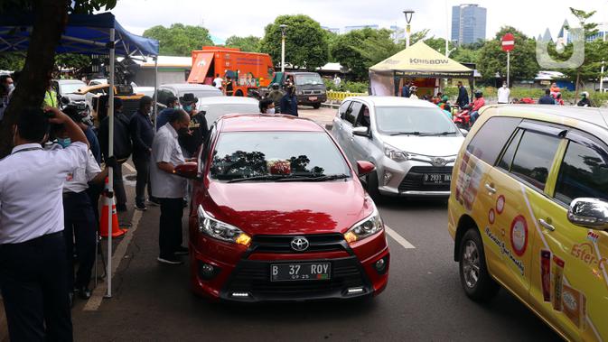 Antrean pengendara mobil saat uji emisi gratis di Jakarta Barat, Rabu (13/1/2021). Dinas Lingkungan Hidup DKI Jakarta mengumumkan kendaraan yang tidak mengikuti uji emisi atau tidak lulus uji emisi gas buang akan dikenakan disinsentif tarif parkir yang tinggi dan tilang. (Liputan6.com/Angga Yuniar)