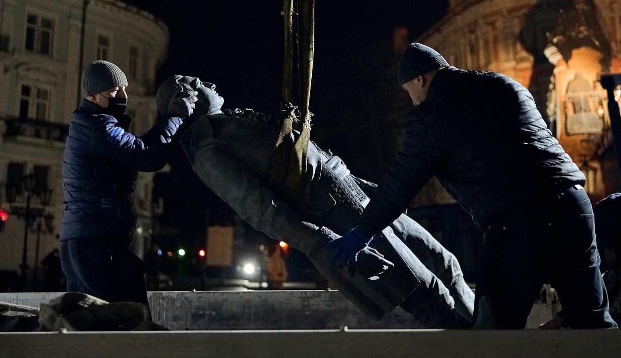 Pekerja memindahkan sebagian monumen untuk Catherine II yang juga dikenal sebagai "Monumen Pendiri Odesa" di Odesa, Ukraina, 29 Desember 2022. Keputusan untuk membongkar monumen yang terdiri dari patung Permaisuri Rusia Catherine II dan rekannya dibuat baru-baru ini oleh penduduk Odesa melalui pemungutan suara elektronik. (AP Photo/LIBKOS)