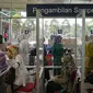 Sejumlah calon penumpang menjalani tes swab PCR di Stasiun Pasar Senen, Jakarta, Jumat (24/12/2021). Layanan ini untuk membantu masyarakat dalam melengkapi persyaratan naik kereta pada masa Natal dan Tahun Baru. (Liputan6.com/Faizal Fanani)