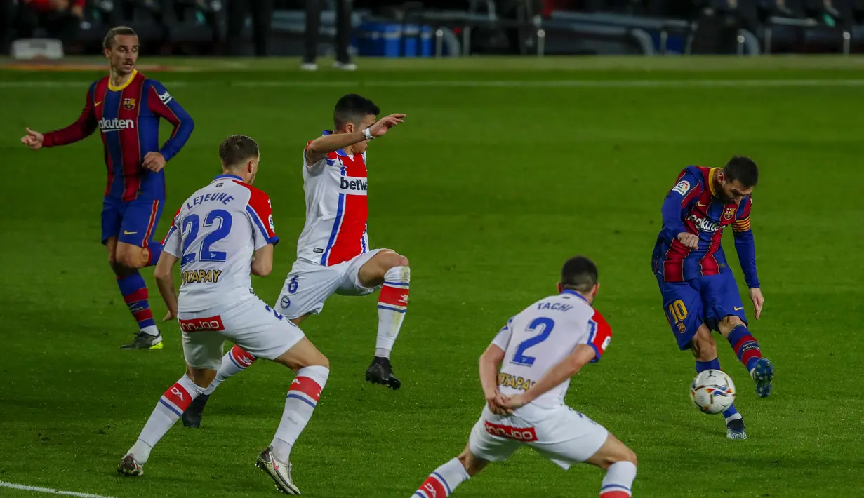 Penyerang Barcelona, Lionel Messi menembak bola ke gawang Deportivo Alaves pada pertandinga La Liga Spanyol di stadion Camp Nou, Spanyol, Minggu (14/2/2021). Barcelona kini berada diuruta kedua dengan 46 angka. (AP Photo/Joan Monfort)