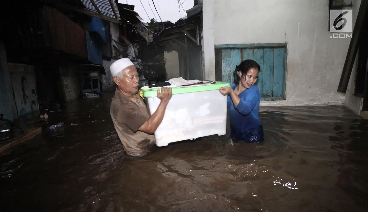 Warga menyelamatkan barang-barangnya saat banjir menggenangi Jalan Kebon Pala, Kampung Melayu, Jatinegara, Jakarta Timur, Senin (5/2). Banjir akibat kiriman dari Bogor ini mencapai ketinggian 70 hingga 100 cm. (Liputan6.com/Arya Manggala)