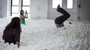 Para karyawan dan masyarakat umum saat bermain dan bersantai di kolam bola yang ada di kantor SoHo, New York City, Selasa (25/8/2015). Ada sekitar 81.000 bola putih disebar diruangan ini. (REUTERS/Mike Segar)