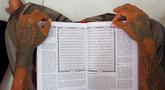 Tangan seorang napi terlihat saat membacakan mushaf Al Quran di sebuah penjara di Serang, Jawa Barat pada 27 Maret 2023. (AFP/Dziki Oktomauliyadi)