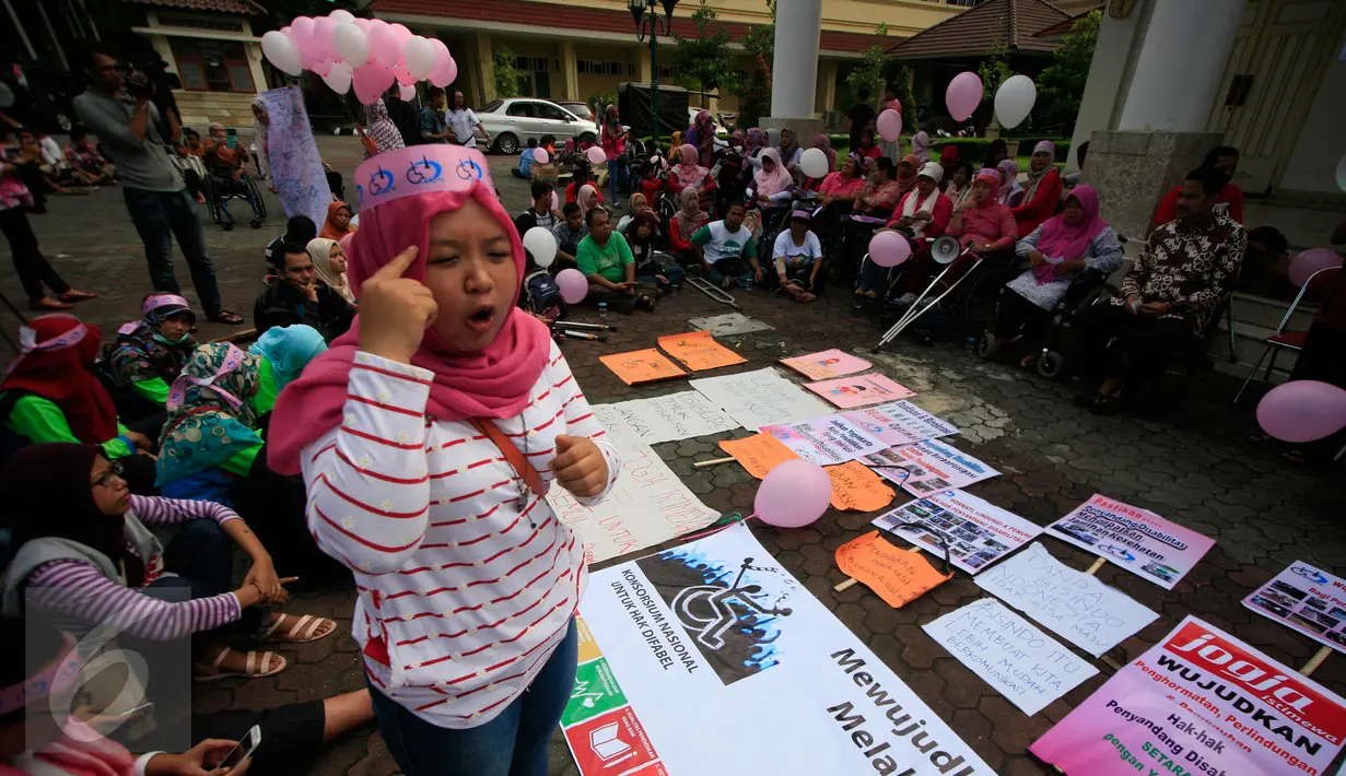 Seorang aktivis menggunakan bahasa isyarat saat mengikuti aksi damai di depan gedung DPRD DIY, Minggu (14/2/2016). Dalam aksinya mereka menuntut aksesibel untuk semua. (Foto: Boy Harjanto)