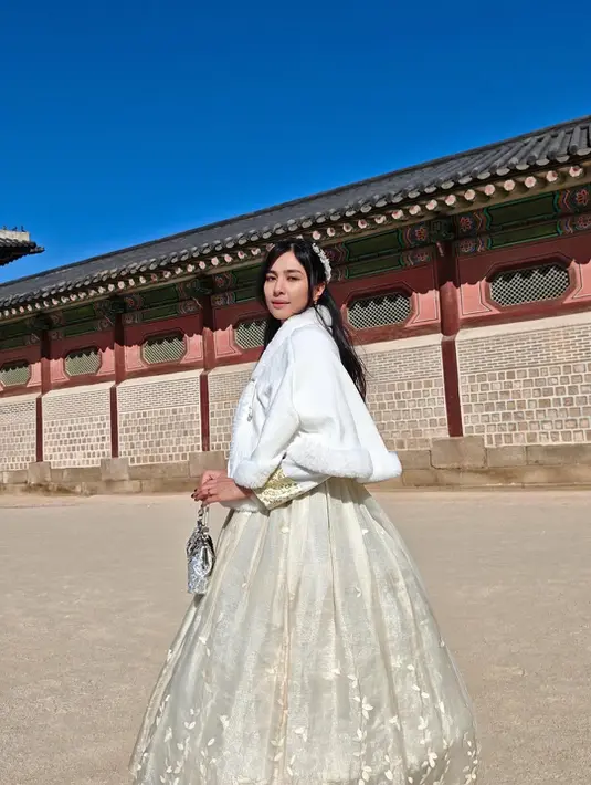 Tak lengkap rasanya ke Korea Selatan tanpa berbusana ala putri kerajaan. Lagi-lagi ia mengenakan hanbok serba putih yang dibalut dengan coat berbulut [@miktambayong]