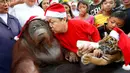 Pendiri Malabon Zoo Manny Tangco mengenakan kostum Santa Claus mencium Orangutan Pacquiao saat merayakan pesta natal di Malabon, Filipina (21/12). (AP Photo / Bullit Marquez)