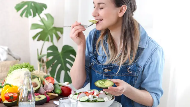 Seorang perempuan sedang makan salad (Foto Dok: Freepik/pvproductions)