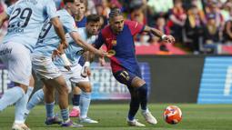 Pemain Barcelona, Raphinha (kanan) menggiring bola dibayangi sejumlah pemain Celta Vigo dalam laga lanjutan Liga Spanyol 2024/2025 di Estadi Olimpic Lluis Companys, Barcelona, Spanyol, Sabtu (19/04/2025). (AP Photo/Joan Monfort)
