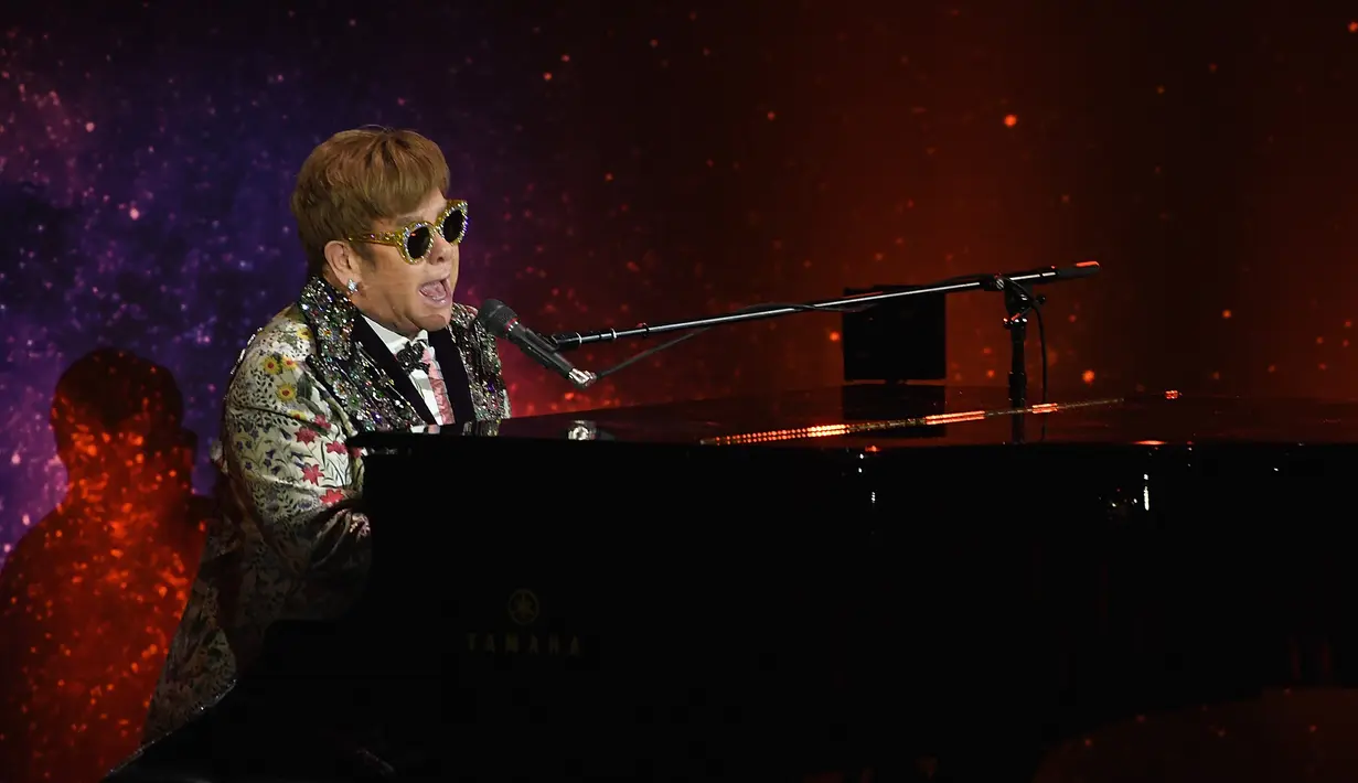 Musikus Elton John tampil bernyanyi sambil bermain piano sebelum mengadakan konferensi pers di New York (24/1). Elton John memutuskan akan menggelar tur perpisahan yang akan dimulai pada September 2018. (Dimitrios Kambouris/Getty Images/AFP)