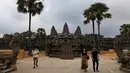 Sejumlah wisatawan berjalan di Candi Angkor Wat, Provinsi Siem Reap, Kamboja, Kamis (5/3/2020). Menurut World Travel and Tourism Council, wabah virus corona (COVID-19) membuat sektor pariwisata dunia kehilangan USD 22 miliar. (TANG CHHIN Sothy/AFP)