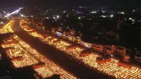 Orang-orang menyalakan lampu di tepi sungai Saryu di Ayodhya, India, Rabu (3/11/2021). Lebih dari 900.000 lampu minyak dinyalakan dan terus menyala selama 45 menit saat kota Ayodhya mempertahankan Rekor Dunia Guinness sebagai bagian dari perayaan festival Diwali. (AP Photo/Rajesh Kumar Singh)