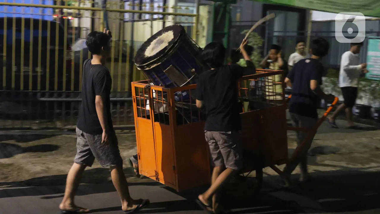 FOTO: Bangunkan Warga Sahur dengan Memukul Bedug Keliling Kampung