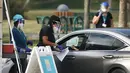 Petugas kesehatan bersiap untuk memberikan vaksin virus corona COVID-19 secara drive-thru di Vista View Park, Davie, Florida, Amerika Serikat, 4 Januari 2021. Lokasi vaksinasi COVID-19 drive-thru tersebut disiapkan untuk penduduk Broward yang berusia 65 tahun ke atas. (Joe Raedle/Getty Images/AFP)