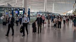 Orang-orang tiba di Bandara Internasional Ibu Kota Beijing untuk melakukan perjalanan menjelang liburan "Golden Week" pada 30 September 2020. Gelombang liburan melanda China yang warganya merayakan libur panjang, yang dikenal dengan Golden Week. (NICOLAS ASFOURI / AFP)