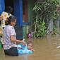 Warga beraktivitas di tengah banjir yang melanda kawasan Cipinang Melayu, Jakarta Timur, Jumat (19/2/2021). Banjir di kawasan tersebut akibat curah hujan yang tinggi dan meluapnya air dari Kali Sunter. (Liputan6.com/Herman Zakharia)