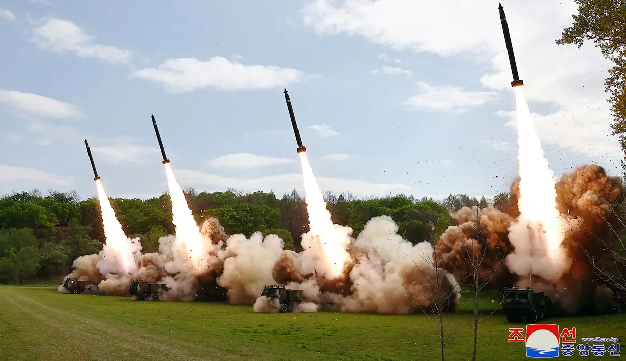 Foto-foto media KCNA menunjukkan setidaknya empat roket ditembakkan dari kendaraan peluncur saat Kim menyaksikan dari pos pengamatan. (STR / KCNA VIA KNS / AFP)
