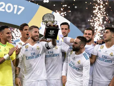 Sergio Ramos (tengah) mengangkat trofi Piala Super Spanyol 2017 usai mengalahkan Barcelona  pada leg kedua Piala Super Spanyol di Santiago Bernabeu stadium (16/8/2017). Real menang 2-0. (AFP/Javier Soariano)